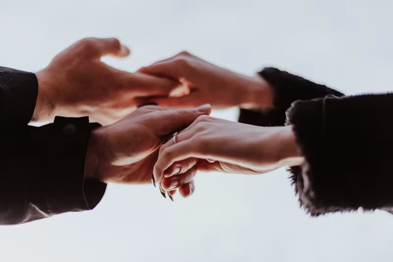 Two people's hands gently reaching for one another, symbolizing support in trauma therapy